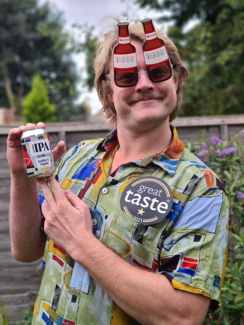 The founder of Jiddler's Tipple holding a can of their IPA